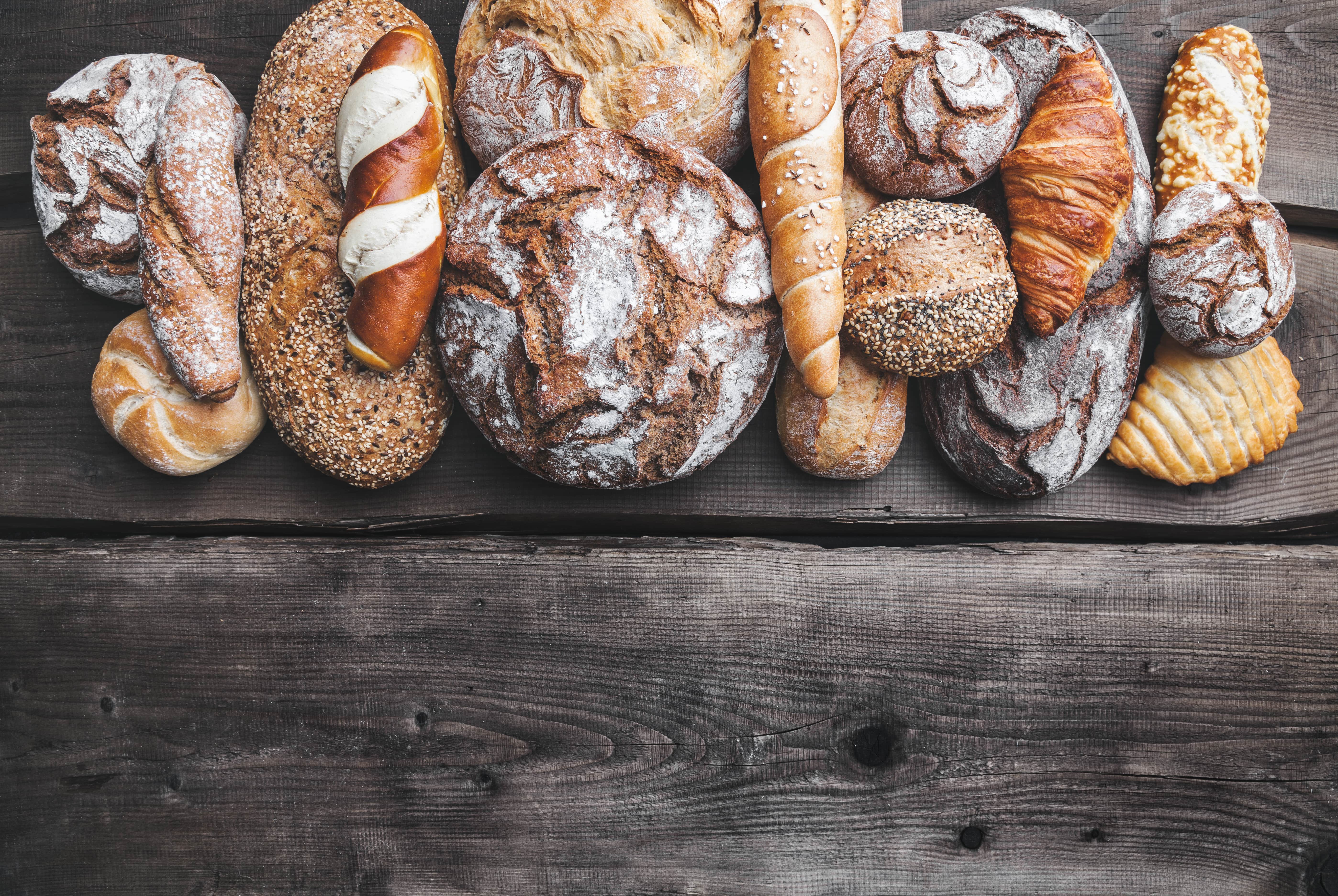 delicious-fresh-bread-on-wooden-background-P9FSLCH-min